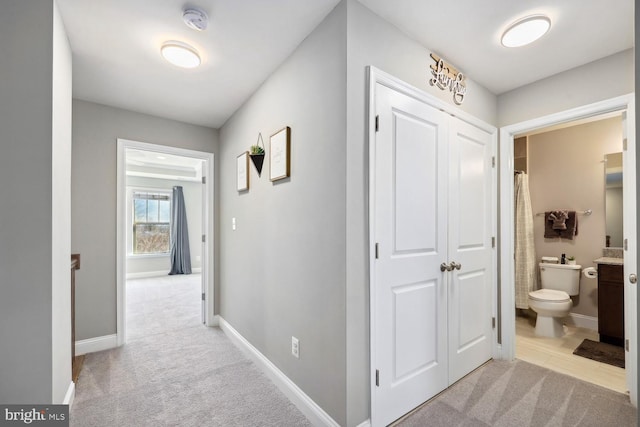 hall featuring carpet floors and baseboards