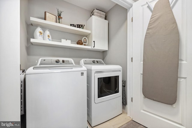 washroom featuring cabinet space and washing machine and clothes dryer