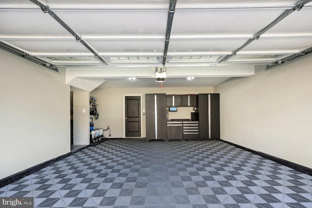 garage featuring a garage door opener and baseboards