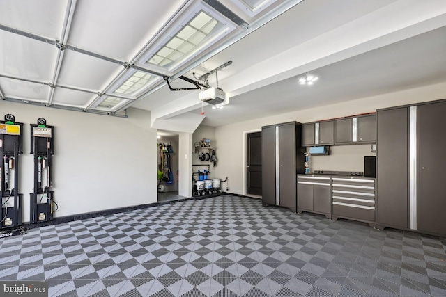 garage with baseboards and a garage door opener