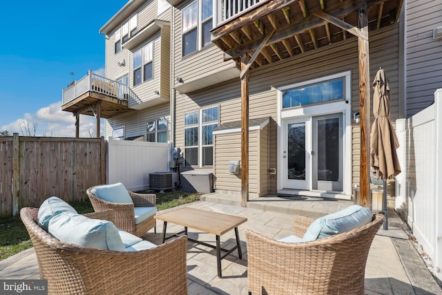 view of patio with an outdoor hangout area, central AC unit, and fence