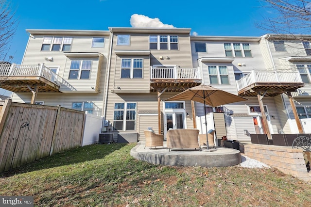 rear view of property with central AC, fence, a lawn, and a patio