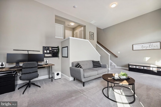 carpeted living area featuring stairway and baseboards