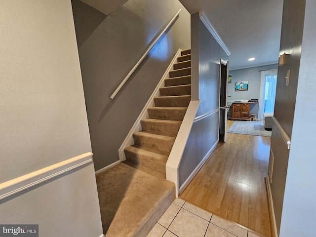 staircase featuring tile patterned flooring, crown molding, and baseboards