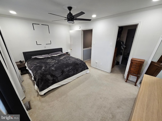 bedroom featuring a walk in closet, recessed lighting, light colored carpet, ornamental molding, and baseboards