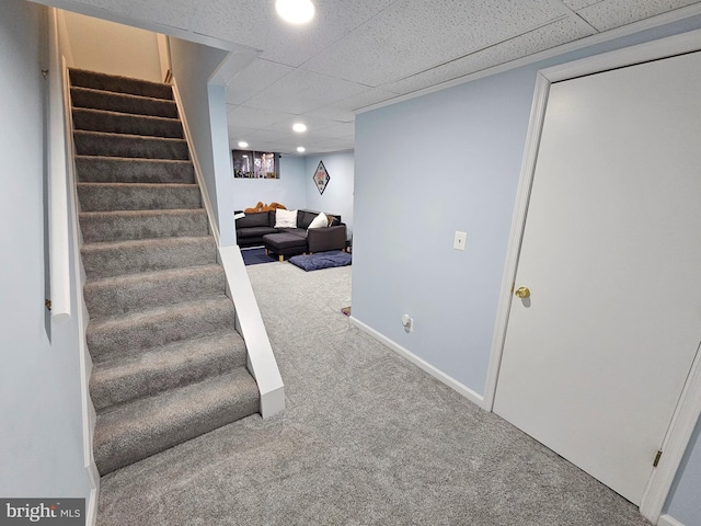 finished basement with carpet floors, recessed lighting, a drop ceiling, baseboards, and stairs