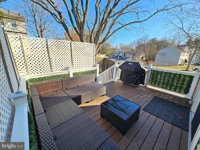 wooden terrace with a grill and an outdoor hangout area