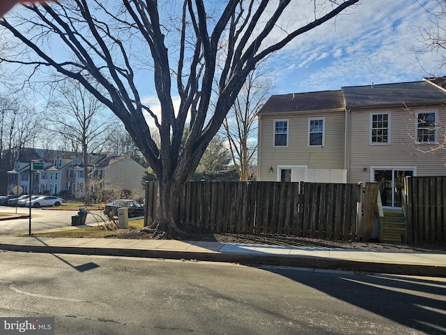 view of side of property featuring a residential view and fence