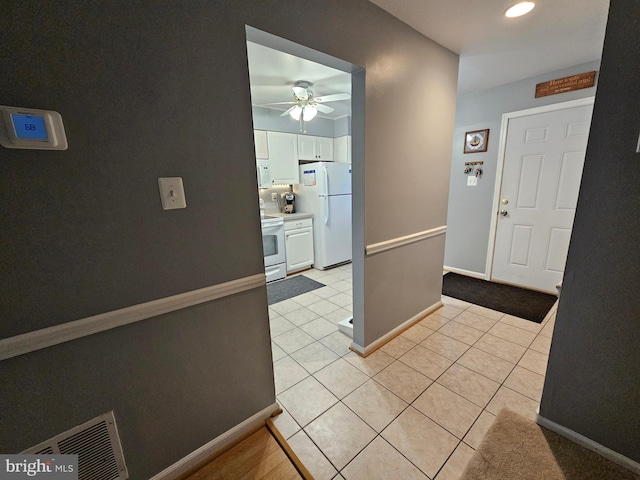 foyer entrance featuring light tile patterned floors, a ceiling fan, visible vents, and baseboards