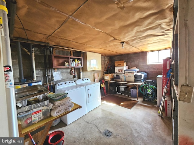 basement featuring concrete block wall and washer and clothes dryer