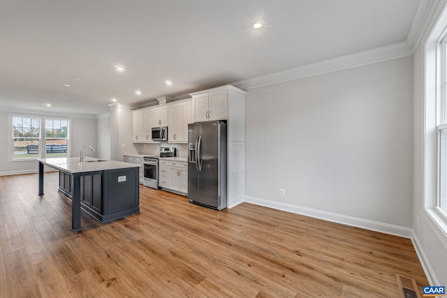 kitchen featuring stainless steel appliances, a breakfast bar, a sink, white cabinetry, and a center island with sink