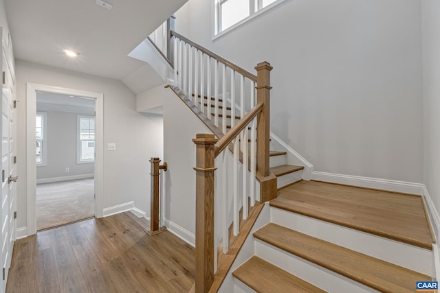 staircase featuring baseboards, wood finished floors, and recessed lighting