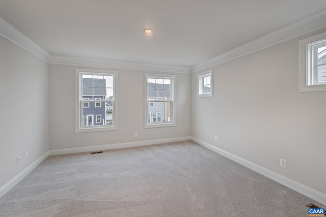 spare room featuring light carpet, baseboards, visible vents, and crown molding