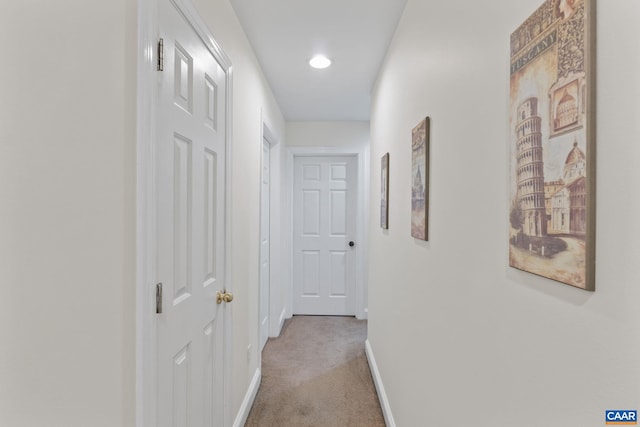 hall featuring light carpet and baseboards