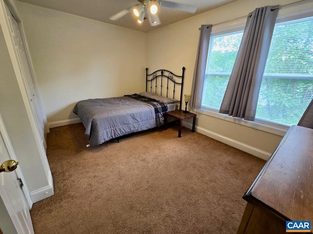 carpeted bedroom featuring a ceiling fan and baseboards