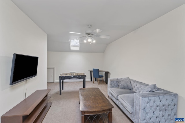 living room featuring light carpet, ceiling fan, and vaulted ceiling with skylight