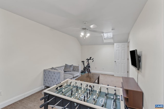 game room with vaulted ceiling with skylight, carpet, baseboards, and ceiling fan