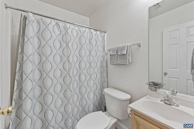 bathroom with curtained shower, vanity, and toilet