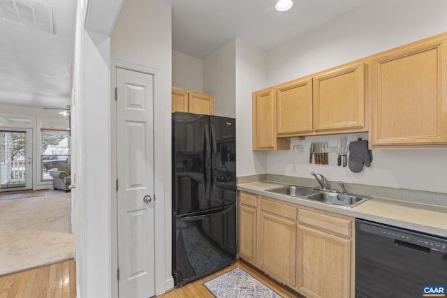 kitchen with light countertops, visible vents, light brown cabinets, a sink, and black appliances