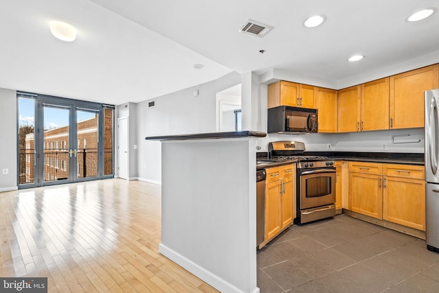 kitchen with dark countertops, recessed lighting, visible vents, appliances with stainless steel finishes, and baseboards