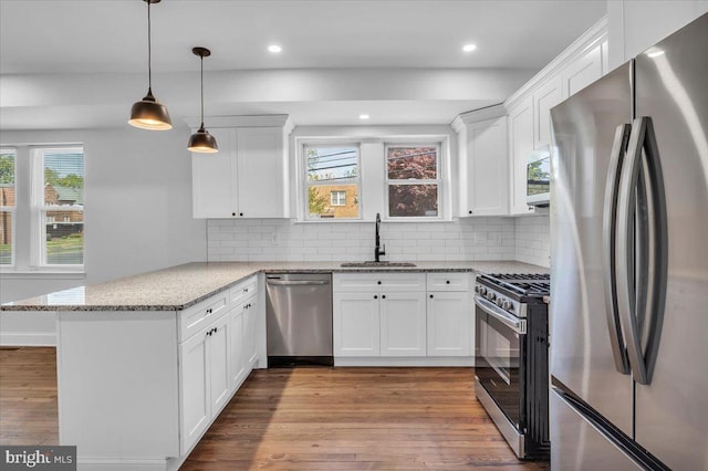 2782 Yorkship Rd, Camden, NJ 08104 - kitchen with a sink, a peninsula, wood finished floors, white cabinetry, and appliances with stainless steel finishes