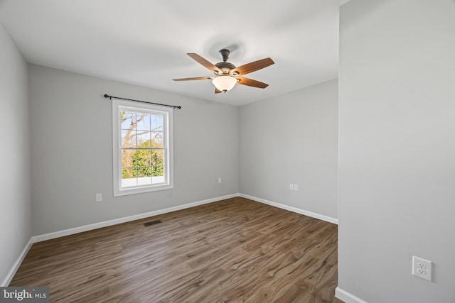 spare room with visible vents, baseboards, ceiling fan, and wood finished floors