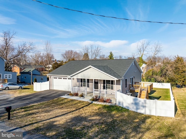 view of front of home featuring a porch, a front yard, fence, a garage, and driveway