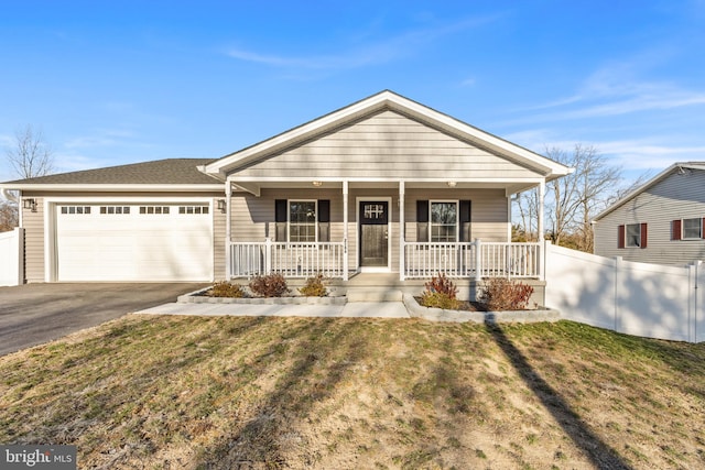 view of front of house with aphalt driveway, an attached garage, fence, a porch, and a front yard