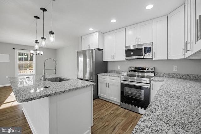 kitchen featuring appliances with stainless steel finishes, white cabinetry, a sink, and dark wood-style floors