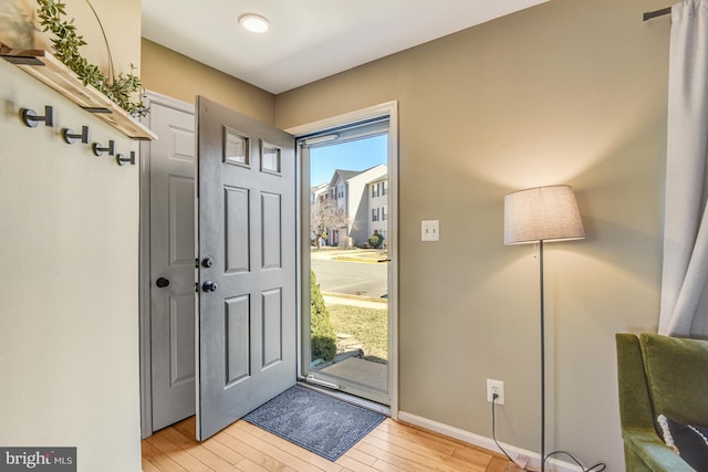 entrance foyer with a wealth of natural light, baseboards, and light wood finished floors