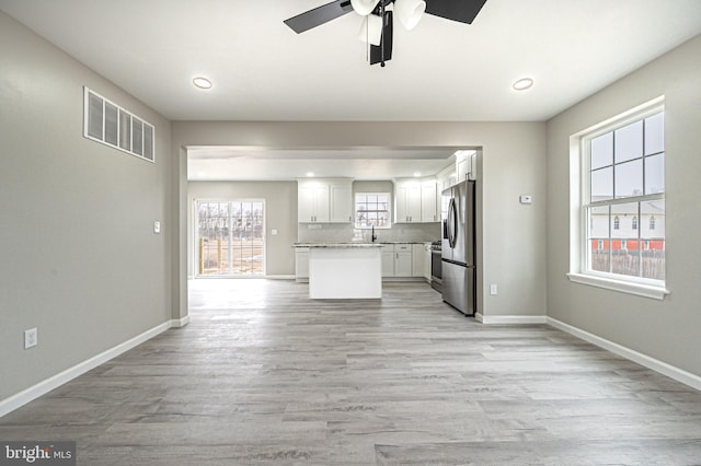 kitchen with light countertops, visible vents, appliances with stainless steel finishes, open floor plan, and white cabinetry