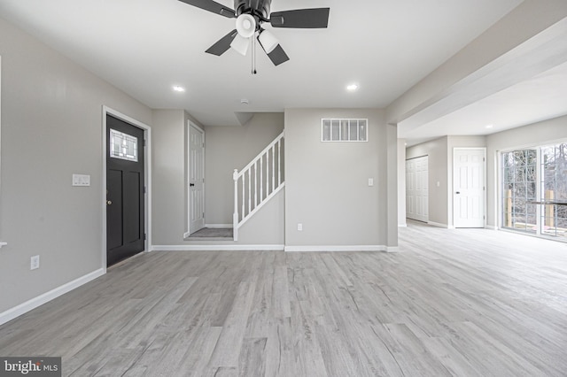 entrance foyer with stairs, light wood-type flooring, visible vents, and baseboards