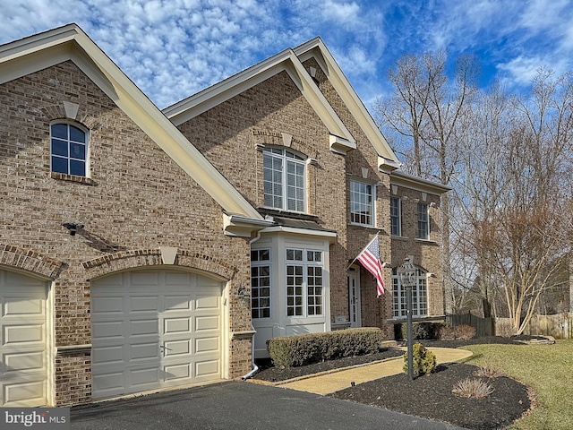 view of front facade featuring a garage, aphalt driveway, and brick siding