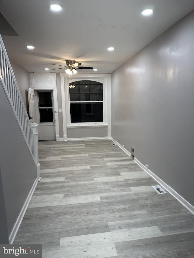 corridor featuring baseboards, stairway, wood finished floors, and recessed lighting