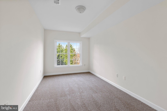 carpeted empty room with visible vents and baseboards