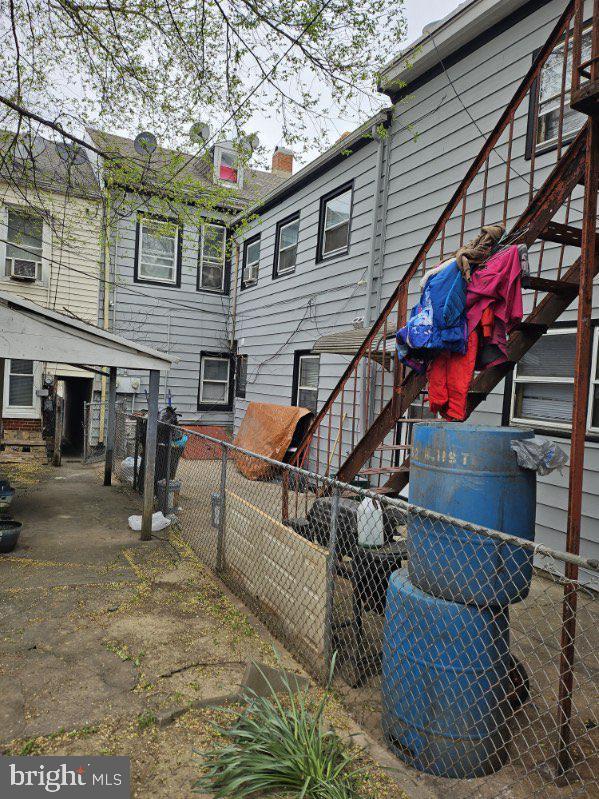 back of property with cooling unit, fence, and a chimney