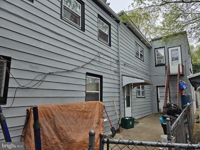 rear view of property featuring a patio and fence