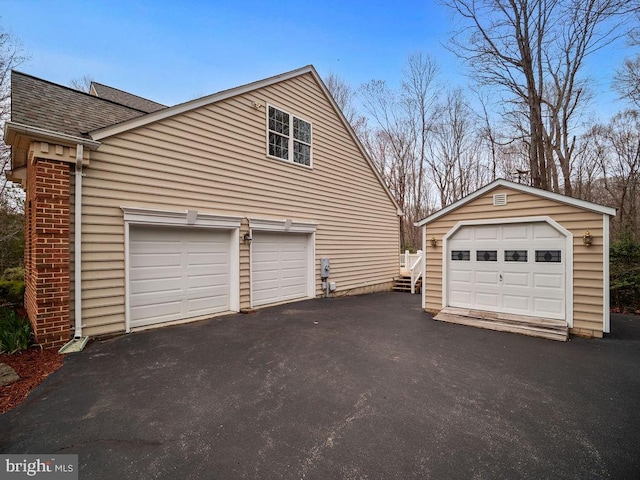 3110 Blackberry Ln, Prince Frederick, MD 20678 - view of side of property featuring a garage, a shingled roof, driveway, and an outbuilding