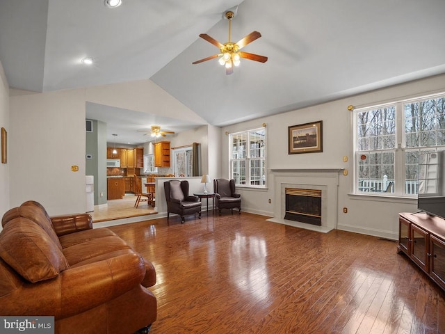3110 Blackberry Ln, Prince Frederick, MD 20678 - living room featuring a fireplace with flush hearth, a ceiling fan, vaulted ceiling, wood finished floors, and baseboards