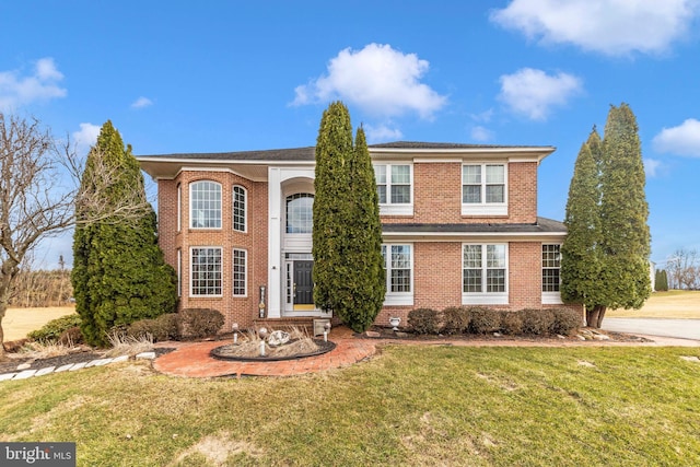 view of front of property featuring brick siding and a front yard