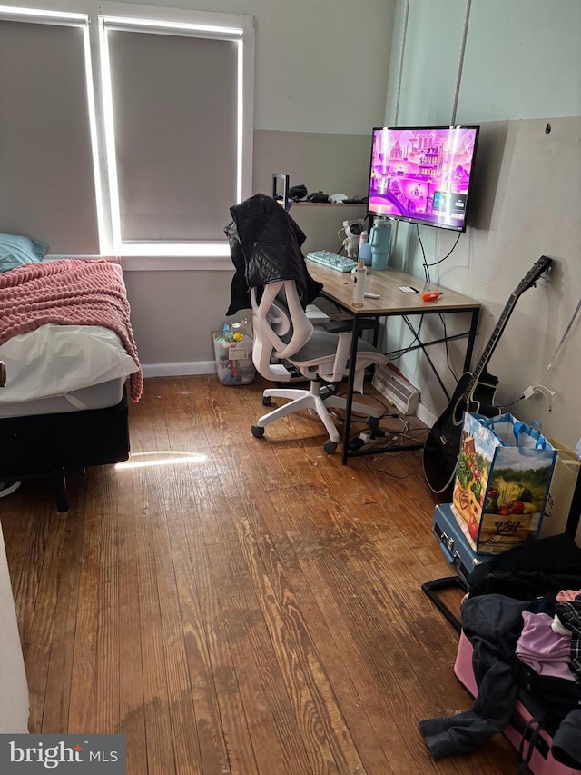 bedroom with baseboards and wood finished floors