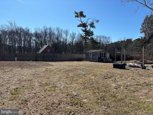 view of yard with fence and an outbuilding