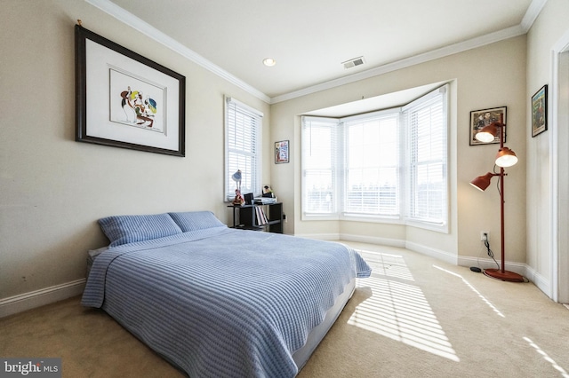 carpeted bedroom featuring baseboards, visible vents, and crown molding