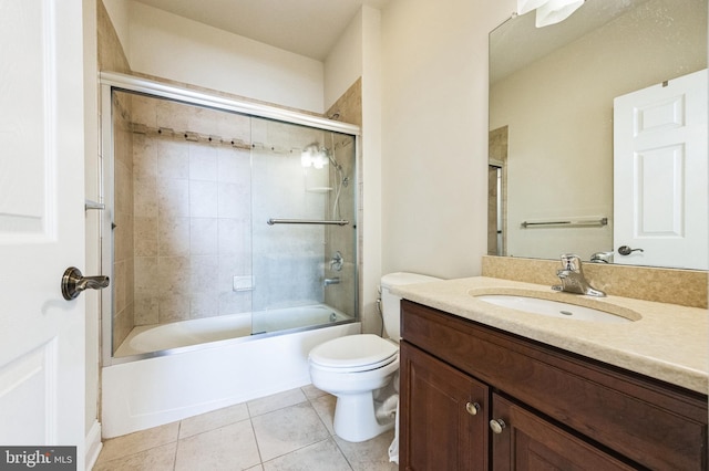 bathroom with toilet, vanity, combined bath / shower with glass door, and tile patterned floors