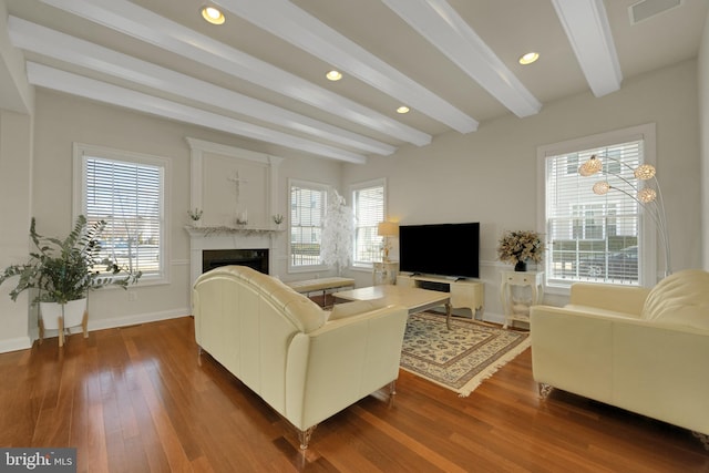 living area featuring a healthy amount of sunlight, visible vents, dark wood-style flooring, and a premium fireplace