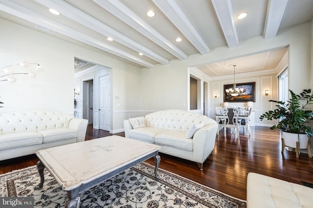 living room with dark wood-type flooring, beam ceiling, and a notable chandelier