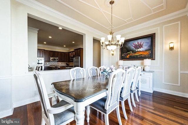 dining room with a chandelier, crown molding, dark wood finished floors, and a decorative wall