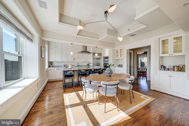 dining space featuring a raised ceiling, visible vents, dark wood finished floors, and baseboards