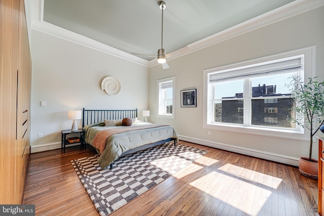 bedroom featuring ornamental molding, baseboards, and hardwood / wood-style flooring