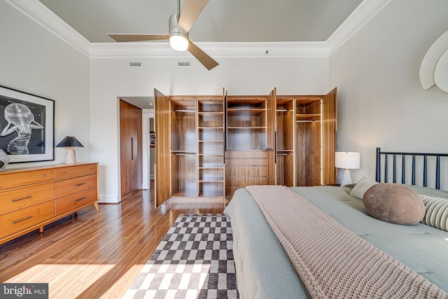 bedroom featuring light wood-style flooring, visible vents, and crown molding